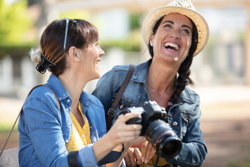 two happy female taking photos with a dslr camera