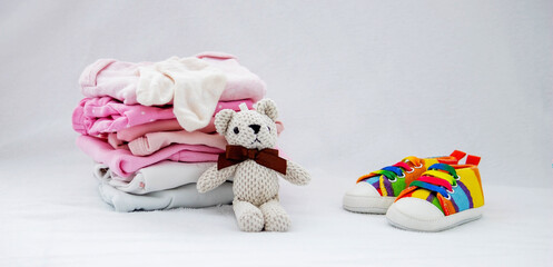 Children's things on a light background. The concept of baby clothes