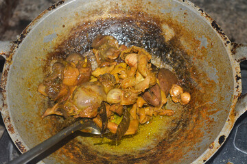 Photo of chicken being cooked on a cauldron