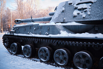 Tank under the snow in the forest. Winter tank camouflage. Battle tank in the snow on the roadside...