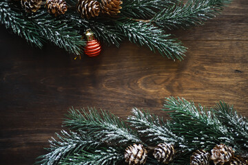 Christmas background with fir tree and decoration on dark wooden board