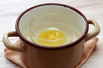 Melting natural beeswax in the bowl. Often used in creams, soaps and other cosmetic eco-products.