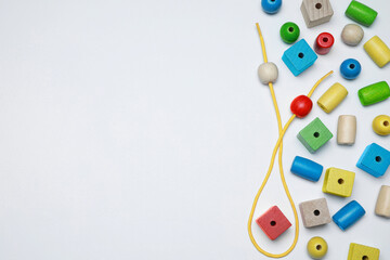 Wooden pieces and string for threading activity isolated on white, top view. Educational toy for...