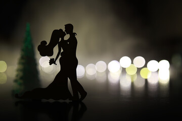 Black silhouettes of pair dancers performing. Man and woman are dancing on gray background with white backlight. Choreography. New Year's ball - obrazy, fototapety, plakaty
