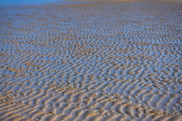 Endless sand structures with water filled ripples at low tide on the beach of Juist island, Germany...