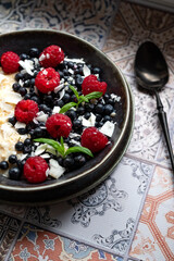 Oatmeal for breakfast with raspberries and blueberries