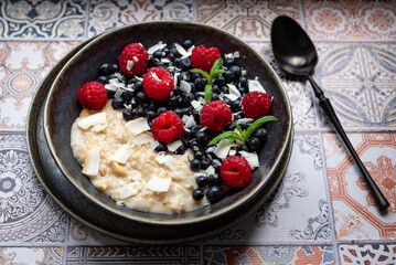 Oatmeal for breakfast with raspberries and blueberries