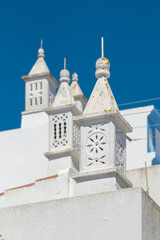 Typical white chimneys on the roofs in South Portugal.