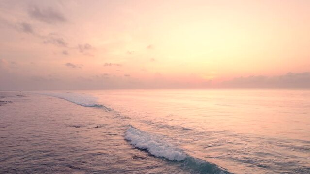 Backward Moving Shot of calm Ocean waves during early morning sunrise 
