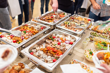 Hands scooping food. Buffet catering meal event concept.