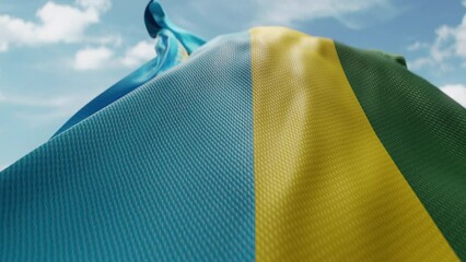 Wavy flag of Rwanda blowing in the wind in slow motion. Waving official Rwandan flag team symbol abstract vertical background. Blue sky with clouds. World countries flying flags concept