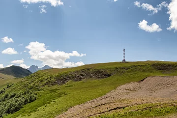 Foto op Plexiglas Mountain landscape with green slopes, cliffs, glaciers and white clouds in the sky © berkut_34