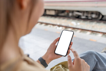 Asian woman using smartphone while waiting train © Natee Meepian