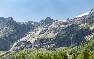View of the valley of Sofia waterfalls with green mountain slopes, rocks and waterfalls