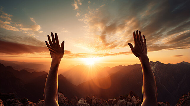 Hands raised on the top of a mountain. Symbol of freedom, achievement. 
