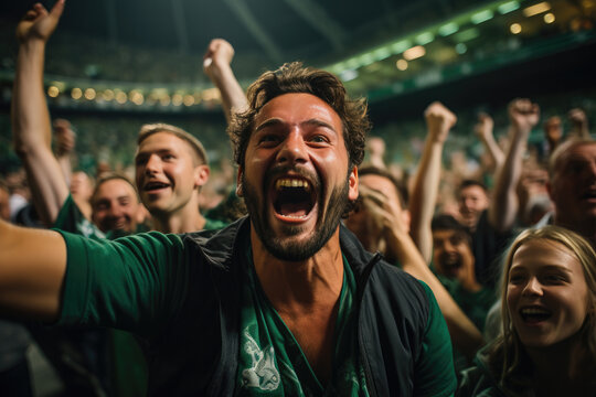 Excited man celebrating goal at football match in crowd