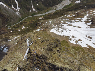 Aerial view of two persons on a mountain peak in the Tyrolean Alps in Austria.