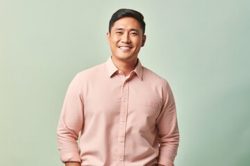 portrait of a confident Filipino man in his 30s wearing a chic cardigan against a pastel or soft colors background