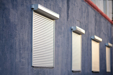 Rolling shutters, windows with closed roller shutters. House facade with window on first floor,...