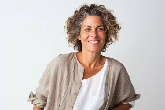 portrait of a confident Israeli woman in her 50s wearing a simple tunic against a white background