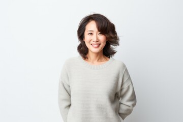 Obraz premium portrait of a confident Japanese woman in her 40s wearing a cozy sweater against a white background