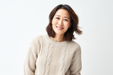portrait of a confident Japanese woman in her 40s wearing a cozy sweater against a white background