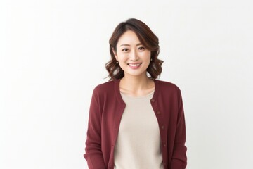 Obraz premium Portrait of a happy Japanese woman in her 30s wearing a chic cardigan against a white background