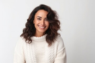 Fototapeta premium portrait of a confident Mexican woman in her 30s wearing a cozy sweater against a white background