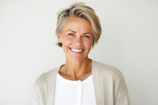 Portrait of a happy Polish woman in her 40s wearing a chic cardigan against a white background