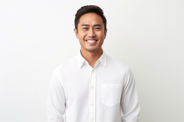Portrait of a Filipino man in his 30s wearing a chic cardigan against a white background - obrazy, fototapety, plakaty