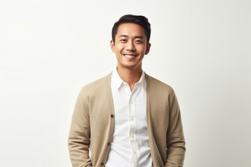 Portrait of a Filipino man in his 30s wearing a chic cardigan against a white background