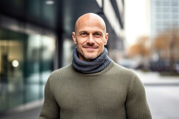 Naklejka premium portrait of a confident Polish man in his 40s wearing a cozy sweater against a modern architectural background
