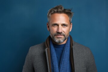 Fototapeta premium portrait of a confident Polish man in his 40s wearing a chic cardigan against an abstract background