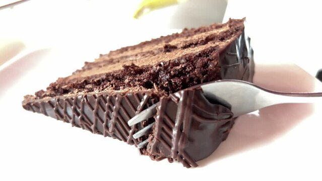A piece of Prague cake. Sweet dessert. Chocolate cake. Homemade Prague cake, piece of cake lies on plate. A delicious dessert for the festive table. A piece of Prague Sweet dessert Chocolate. 