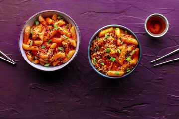 Tteokbokki or topokki and rabokki, Korean street food, spicy rice cakes in red pepper gochujang sauce, shot from the top with a place for text