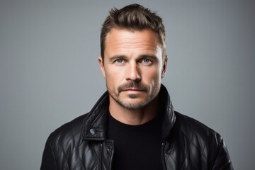 Obraz premium portrait of a serious, Polish man in his 40s wearing a chic cardigan against a white background