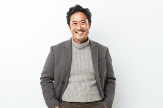 Portrait of a Japanese man in his 40s wearing a chic cardigan against a white background