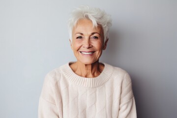 Portrait of a Polish woman in her 80s wearing a cozy sweater against a minimalist or empty room background - obrazy, fototapety, plakaty