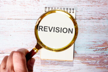 REVISION text seen through magnifying glasses on a notepad