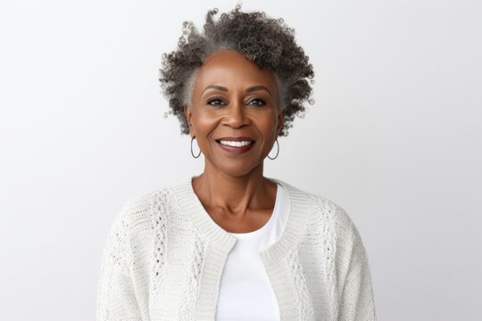 medium shot portrait of a confident Kenyan woman in her 50s wearing a chic cardigan against a white background