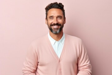medium shot portrait of a confident Mexican man in his 30s wearing a chic cardigan against a pastel or soft colors background