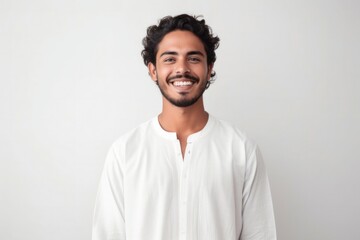 medium shot portrait of a confident Mexican man in his 20s wearing a simple tunic against a white background - obrazy, fototapety, plakaty