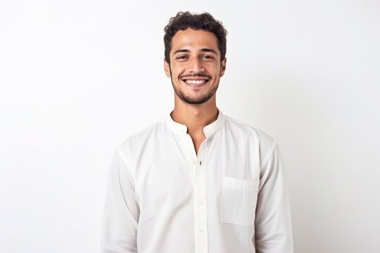 medium shot portrait of a confident Mexican man in his 20s wearing a simple tunic against a white background
