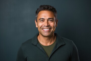 Obraz premium medium shot portrait of a confident Mexican man in his 40s wearing a chic cardigan against an abstract background