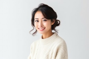 medium shot portrait of a Japanese woman in her 30s wearing a cozy sweater against a white background