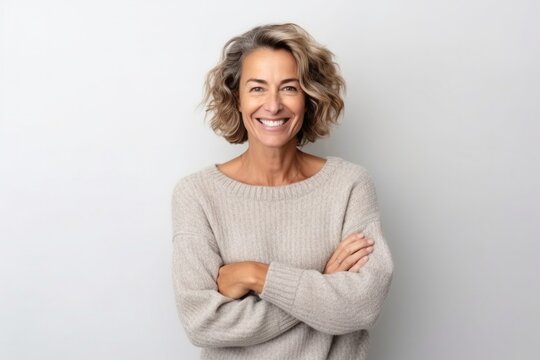 medium shot portrait of a happy Israeli woman in her 40s wearing a cozy sweater against a white background