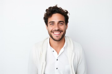 portrait of a happy Israeli man in his 20s wearing a chic cardigan against a white background