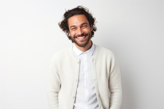 portrait of a happy Israeli man in his 30s wearing a chic cardigan against a white background