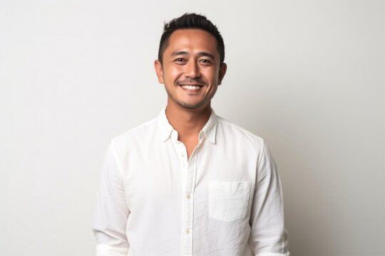 medium shot portrait of a happy Filipino man in his 30s wearing a chic cardigan against a white background