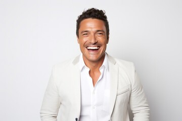 portrait of a happy Mexican man in his 40s wearing a chic cardigan against a white background